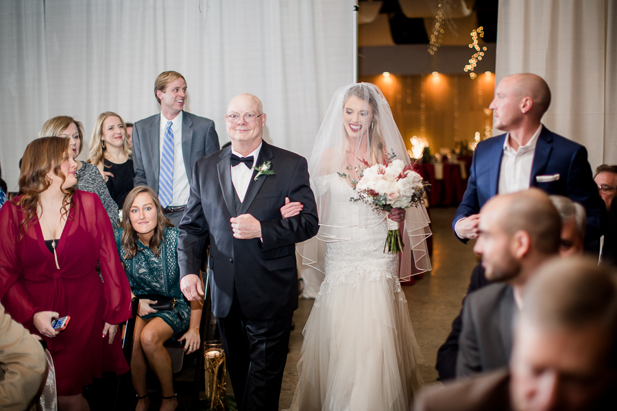 Bride and her dad walking down the aisle during the ceremony pictures at this winter wedding at Knoxville Wedding Venue, Jackson Terminal, by Knoxville Wedding Photographer, Amanda May Photos.