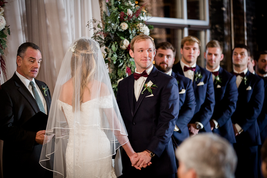 Groom looks out to the audience during the ceremony pictures at this winter wedding at Knoxville Wedding Venue, Jackson Terminal, by Knoxville Wedding Photographer, Amanda May Photos.