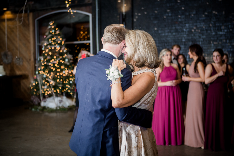 Mother of the groom rests her forehead on the groom during their dance during the reception pictures at this winter wedding at Knoxville Wedding Venue, Jackson Terminal, by Knoxville Wedding Photographer, Amanda May Photos.
