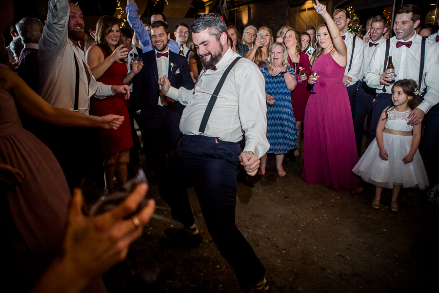 Groomsmen dancing in the middle of the circle during the dancing reception pictures at this winter wedding at Knoxville Wedding Venue, Jackson Terminal, by Knoxville Wedding Photographer, Amanda May Photos.