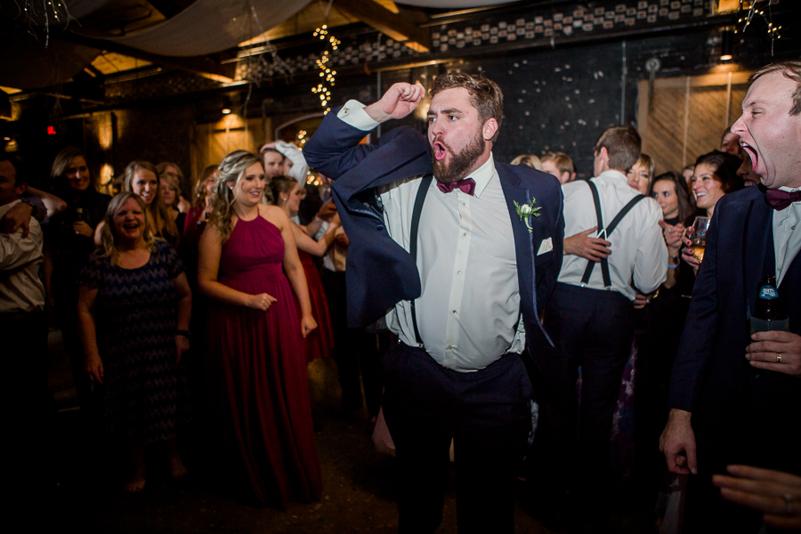 Funny face making his rounds in the middle of the circle during the dancing reception pictures at this winter wedding at Knoxville Wedding Venue, Jackson Terminal, by Knoxville Wedding Photographer, Amanda May Photos.