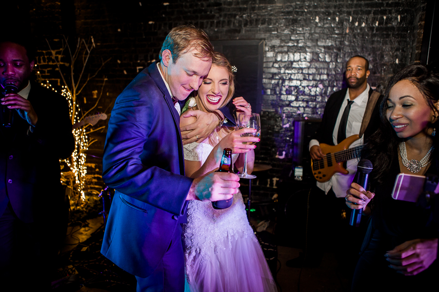 Bride and groom dancing on stage during the dancing reception pictures at this winter wedding at Knoxville Wedding Venue, Jackson Terminal, by Knoxville Wedding Photographer, Amanda May Photos.