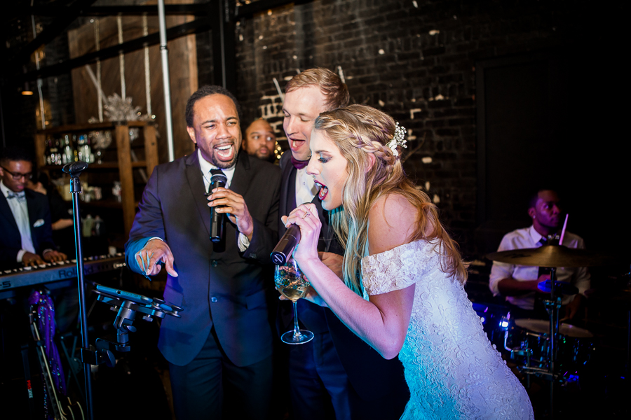 Bride and groom singing with the band during the dancing reception pictures at this winter wedding at Knoxville Wedding Venue, Jackson Terminal, by Knoxville Wedding Photographer, Amanda May Photos.
