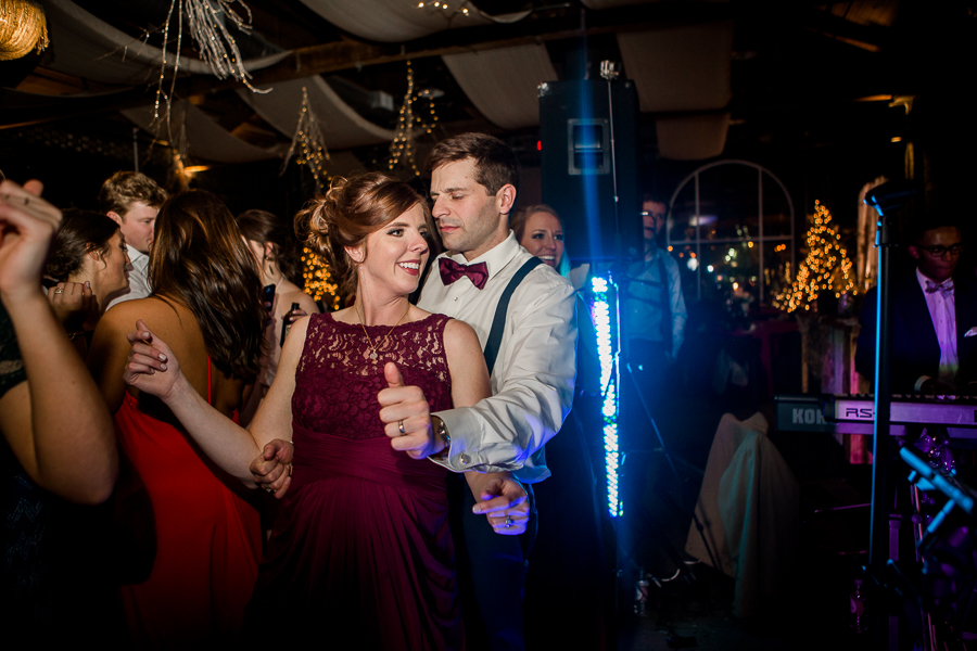 Maid of honor dancing with her husband during the dancing reception pictures at this winter wedding at Knoxville Wedding Venue, Jackson Terminal, by Knoxville Wedding Photographer, Amanda May Photos.
