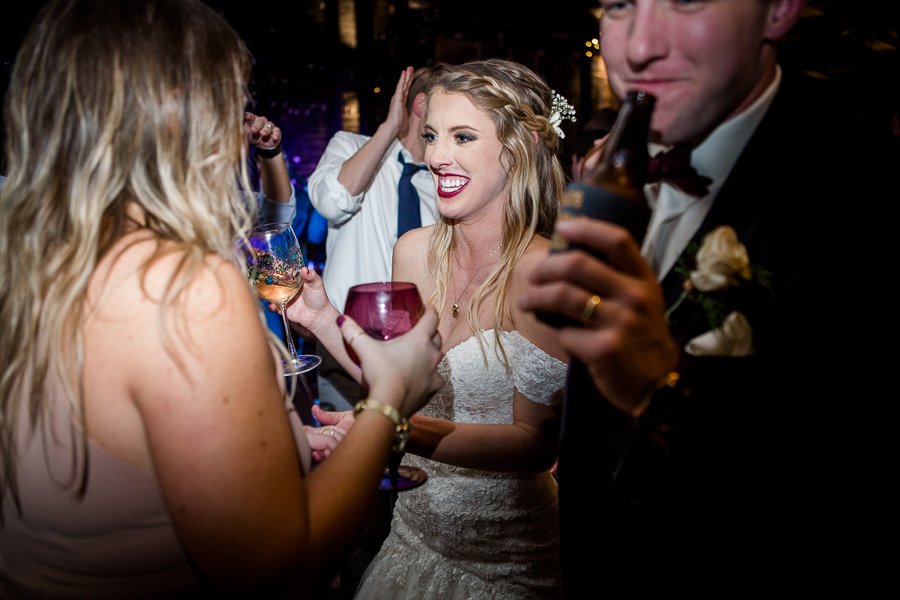 Bride smiling at her guests during the dancing reception pictures at this winter wedding at Knoxville Wedding Venue, Jackson Terminal, by Knoxville Wedding Photographer, Amanda May Photos.