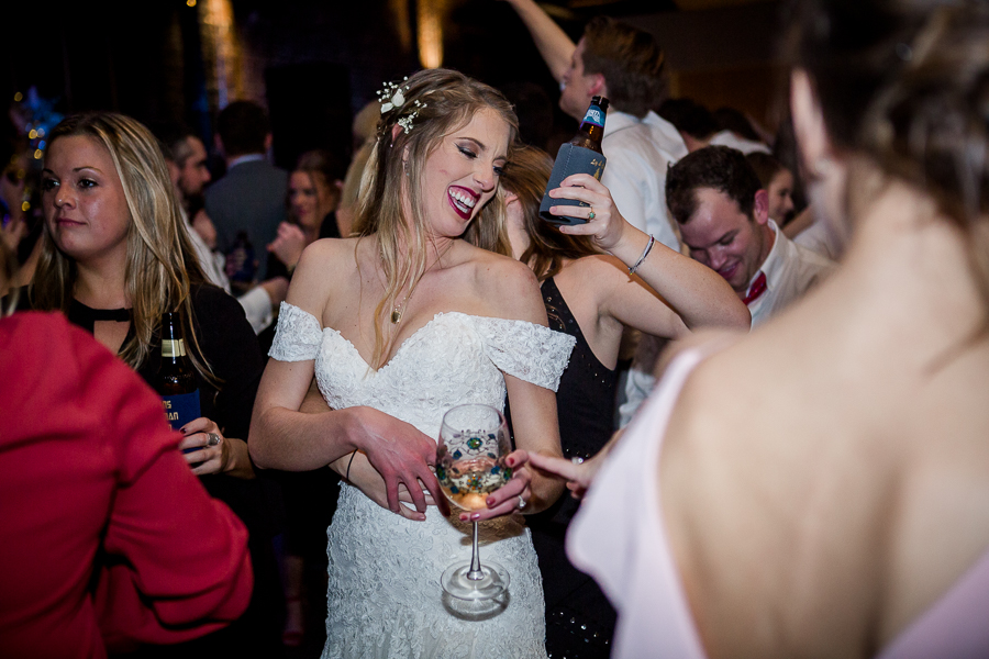 Bride dancing and laughing during the dancing reception pictures at this winter wedding at Knoxville Wedding Venue, Jackson Terminal, by Knoxville Wedding Photographer, Amanda May Photos.