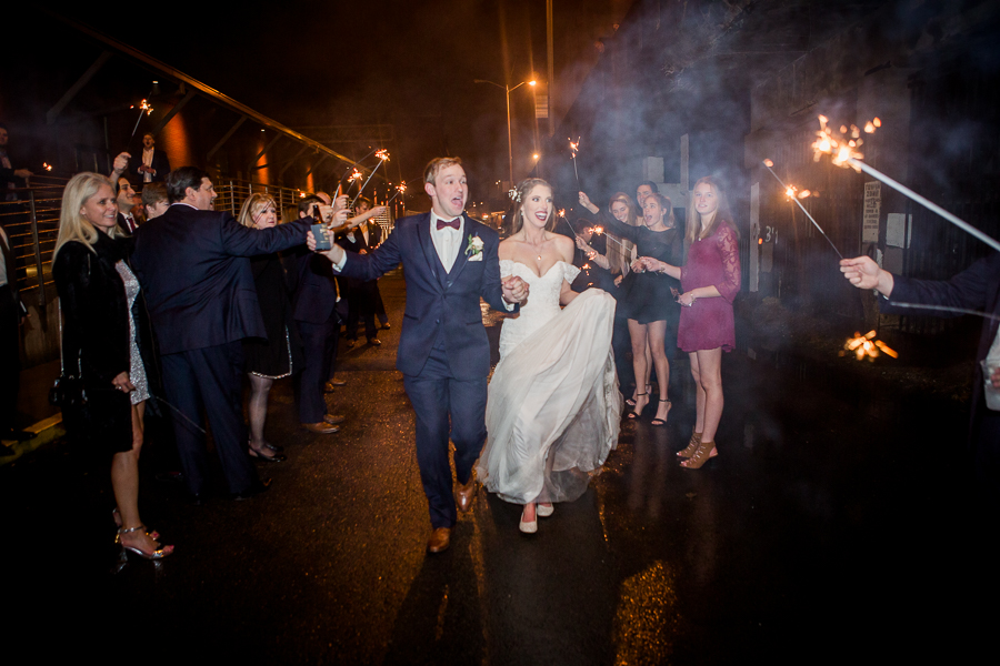 Bride and groom exit between sparklers during the reception pictures at this winter wedding at Knoxville Wedding Venue, Jackson Terminal, by Knoxville Wedding Photographer, Amanda May Photos.