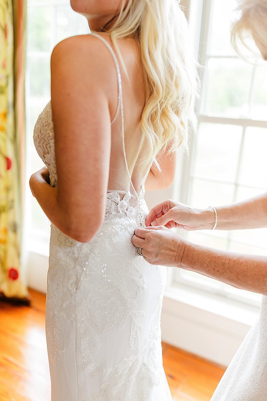 buttoning the wedding dress at this marblegate farm wedding