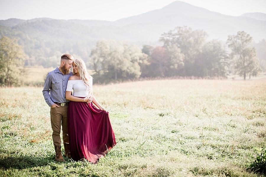 Smiling at each other in grass at this Townsend Anniversary session by Knoxville Wedding Photographer, Amanda May Photos.