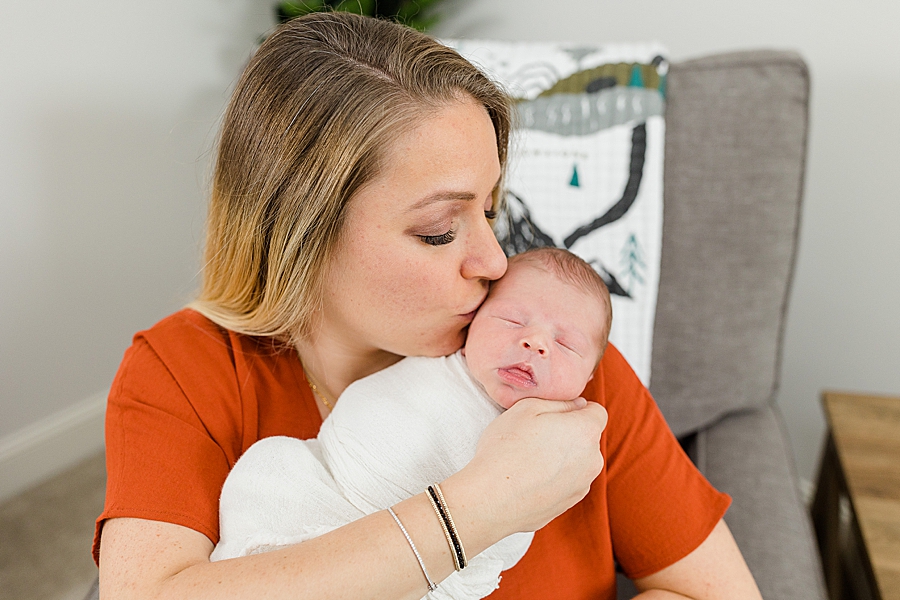 mom kissing baby at this newborn session