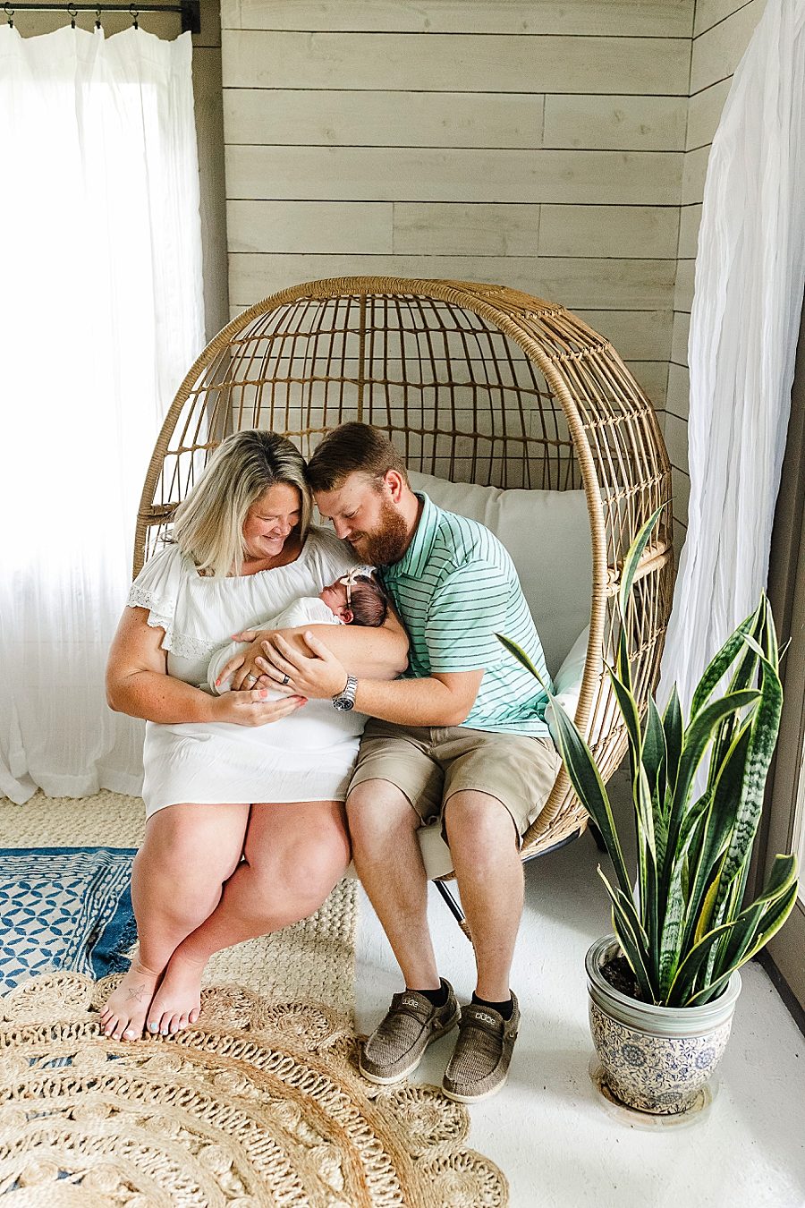 parents sitting in egg chair at this newborn session