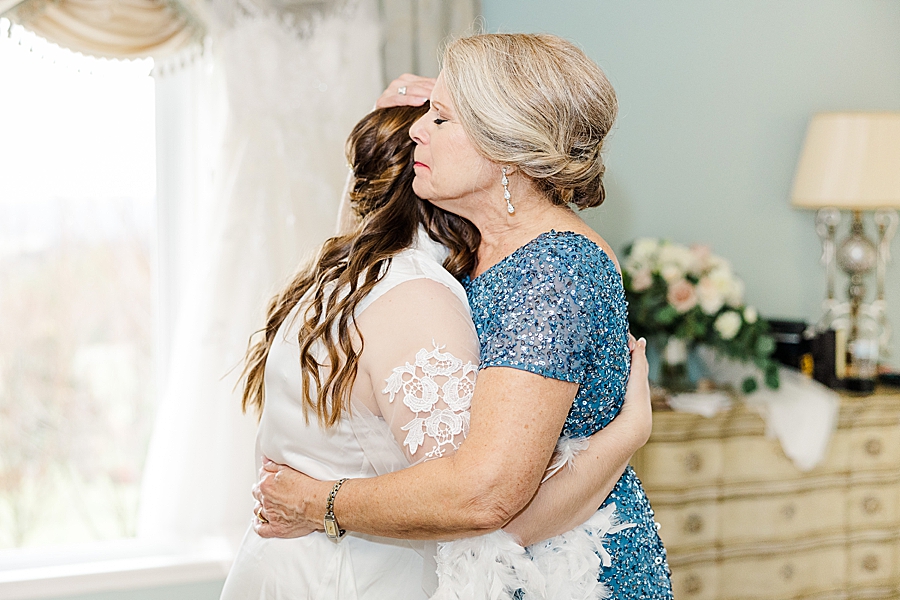 Bride hugging mom at rainy castleton wedding