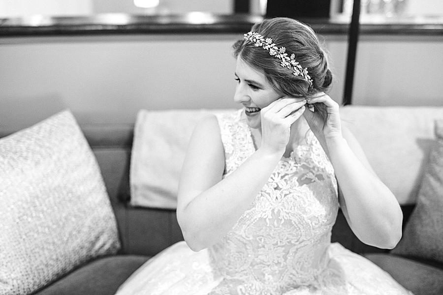 Putting on earrings at this Relix Theater Wedding by Knoxville Wedding Photographer, Amanda May Photos.