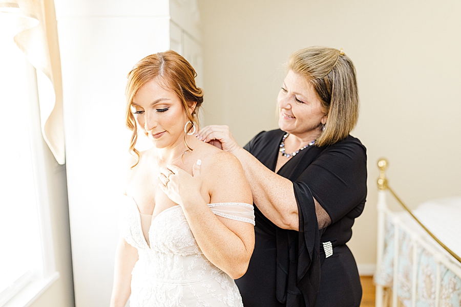 putting on a necklace at this stone gate farm wedding