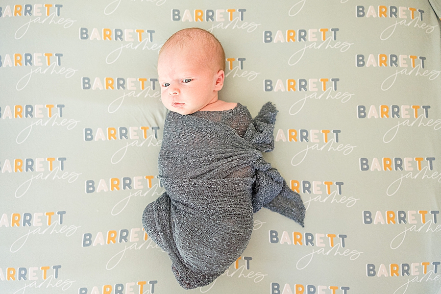 newborn swaddled in dark gray blanket