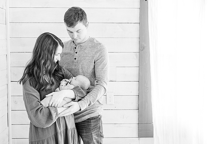 black and white photo of parents holding newborn