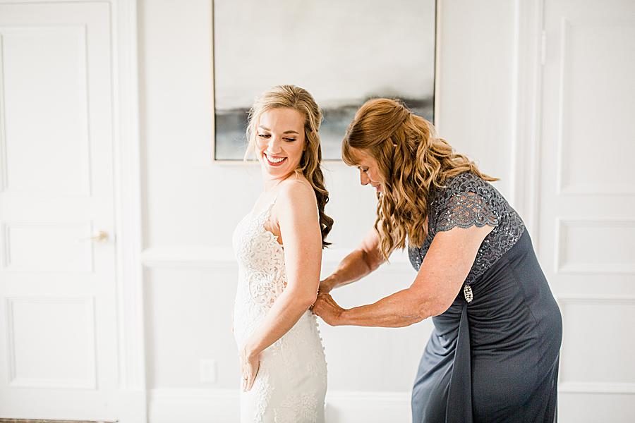 Zipping up the wedding dress by Knoxville Wedding Photographer, Amanda May Photos.