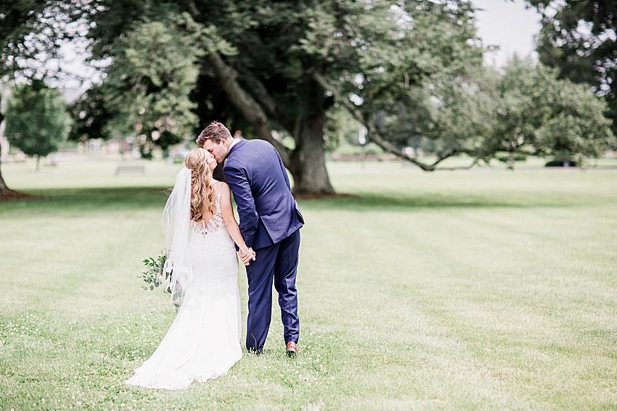 Kissing by an oak tree by Knoxville Wedding Photographer, Amanda May Photos.