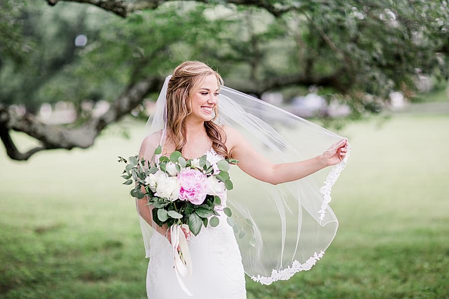 Bride holding out veil at this The Olmsted Wedding by Knoxville Wedding Photographer, Amanda May Photos.
