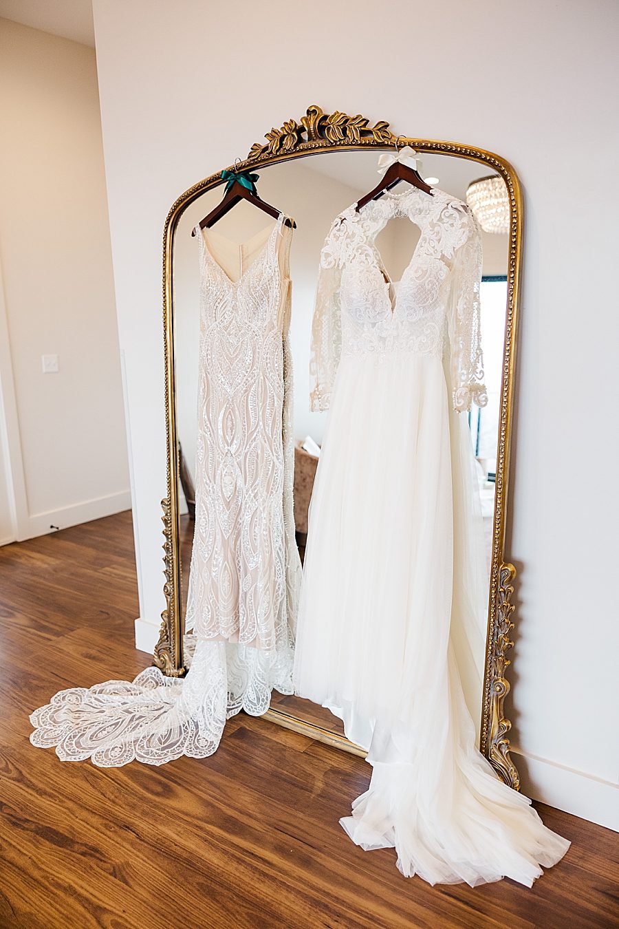 wedding dresses hanging on ornate mirror
