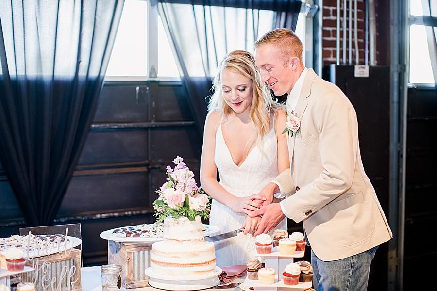 Cutting the cake at this Dayton wedding by Knoxville Wedding Photographer, Amanda May Photos.