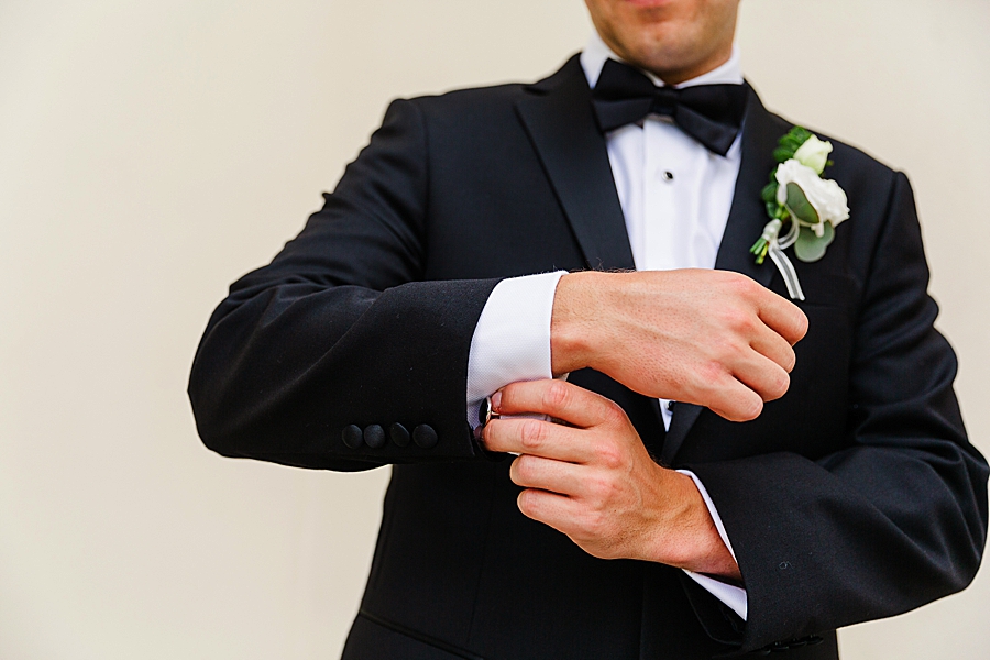 groom straightening sleeves at vineyard wedding at castleton