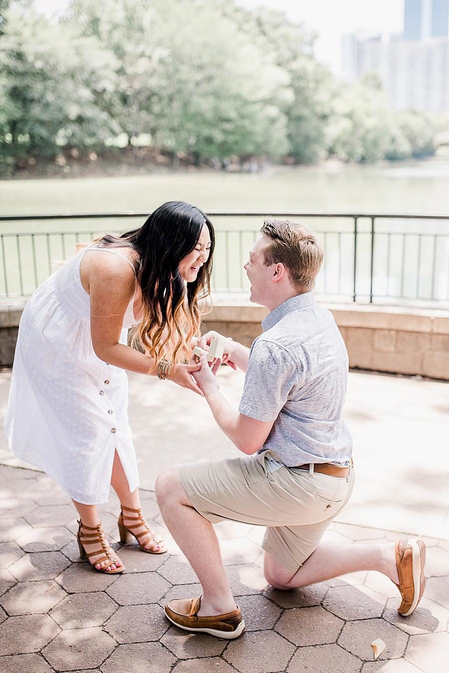 Putting on the ring at this Piedmont Park Proposal by Knoxville Wedding Photographer, Amanda May Photos.