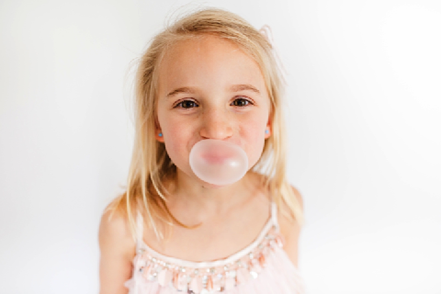 blowing gum bubble at girl party