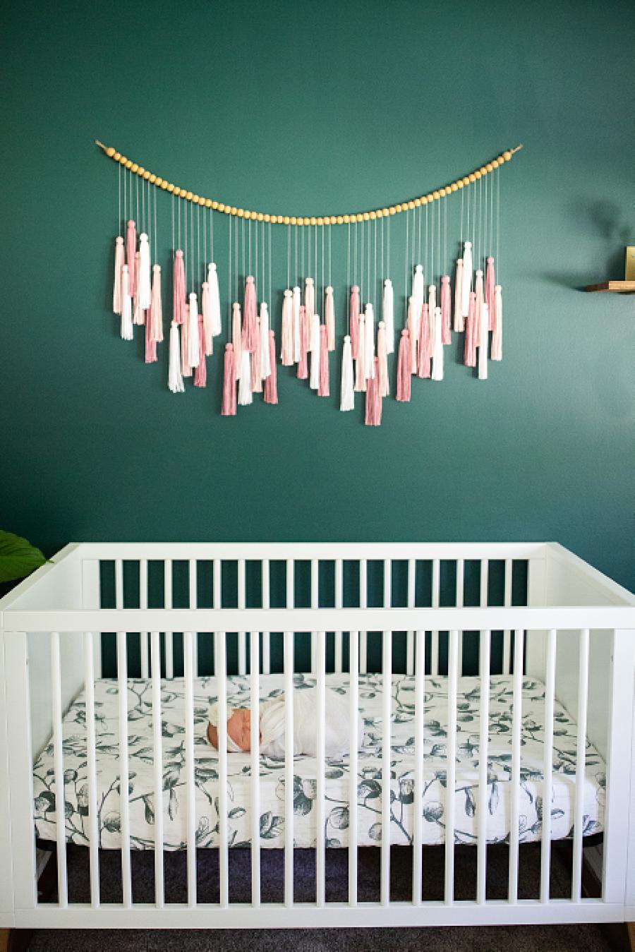 green accent wall in nursery at home newborn