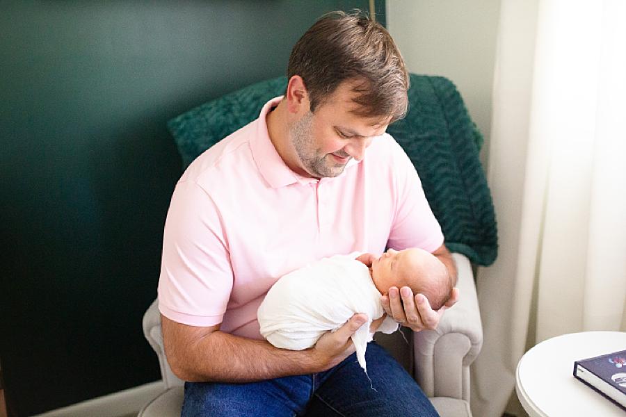 dad holding baby girl at home newborn
