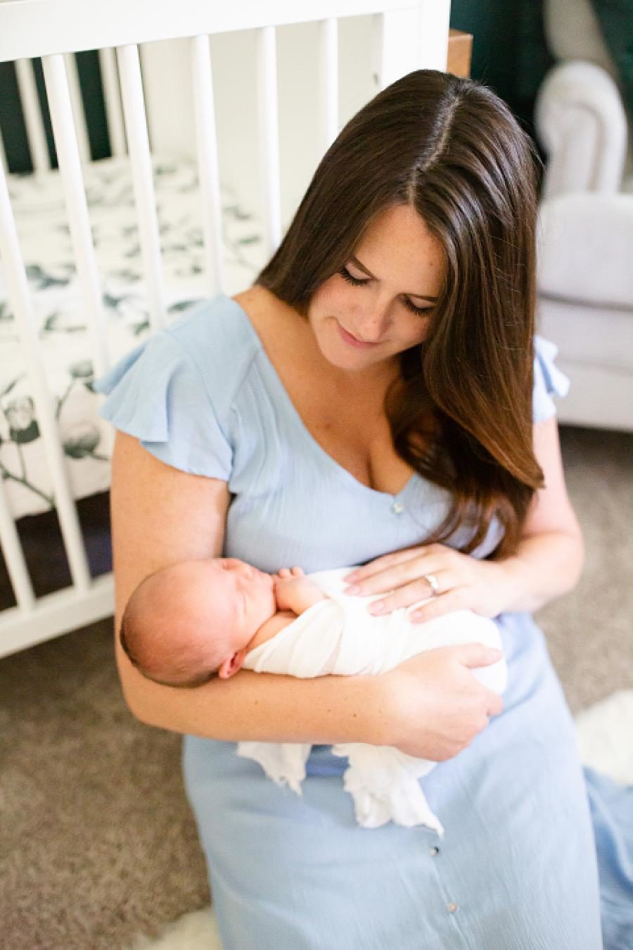 mom holding newborn daughter at home newborn