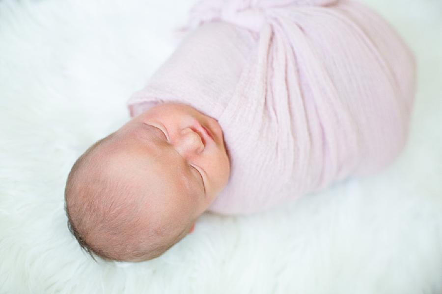 baby in pink swaddle at home newborn
