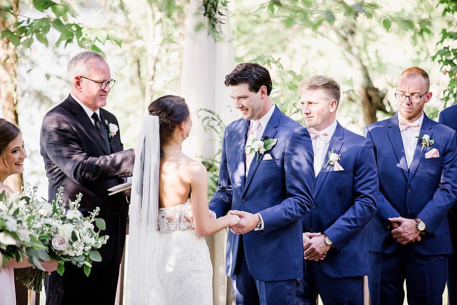 bride holding groom's hands