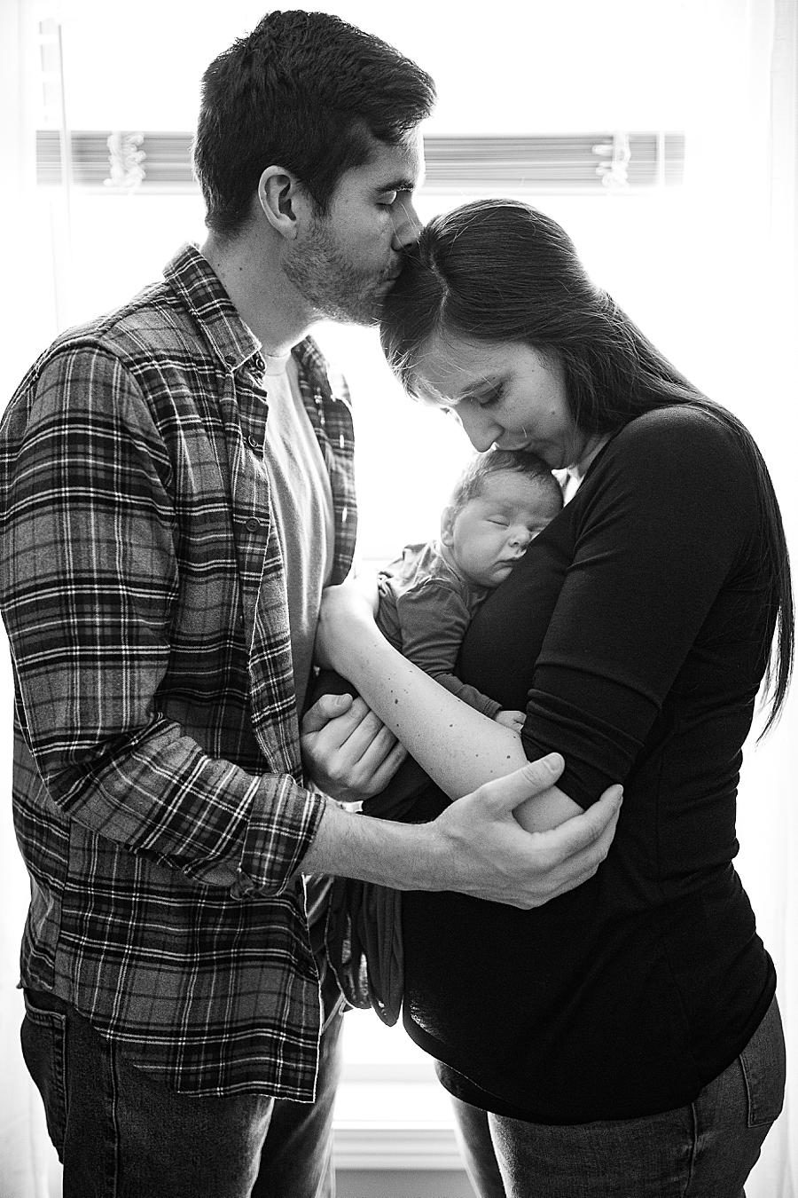 mom and dad holding newborn son