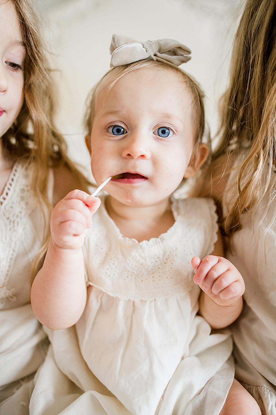 Eating a sucker at this 12 month lifestyle session by Knoxville Wedding Photographer, Amanda May Photos.