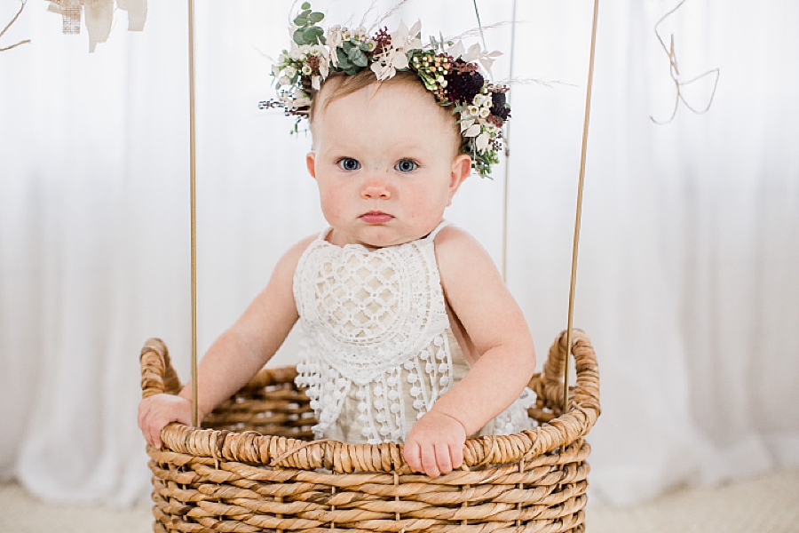 baby in basket with flower crown