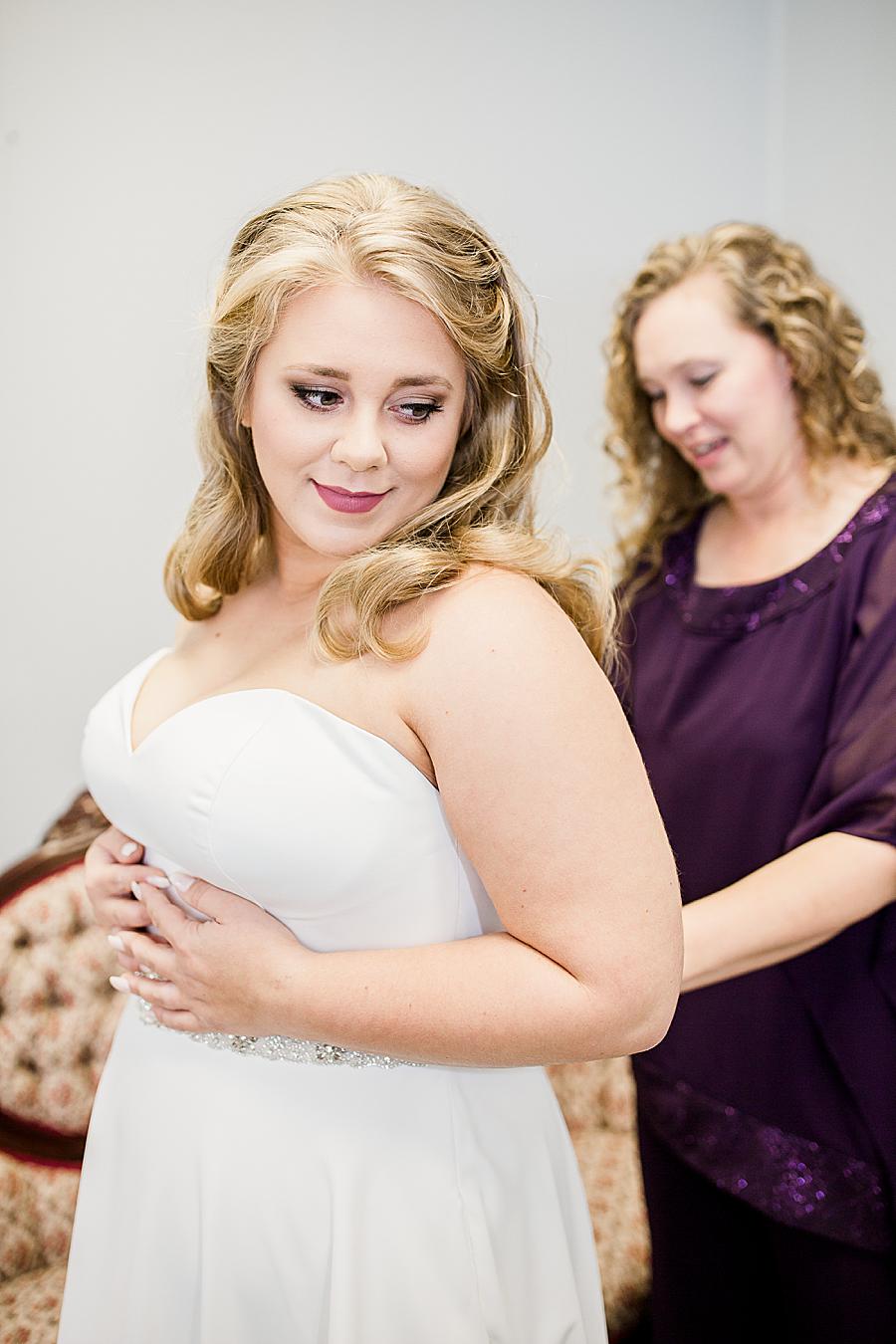 Zipping the dress at this Pine Ridge Baptist Church wedding by Knoxville Wedding Photographer, Amanda May Photos.