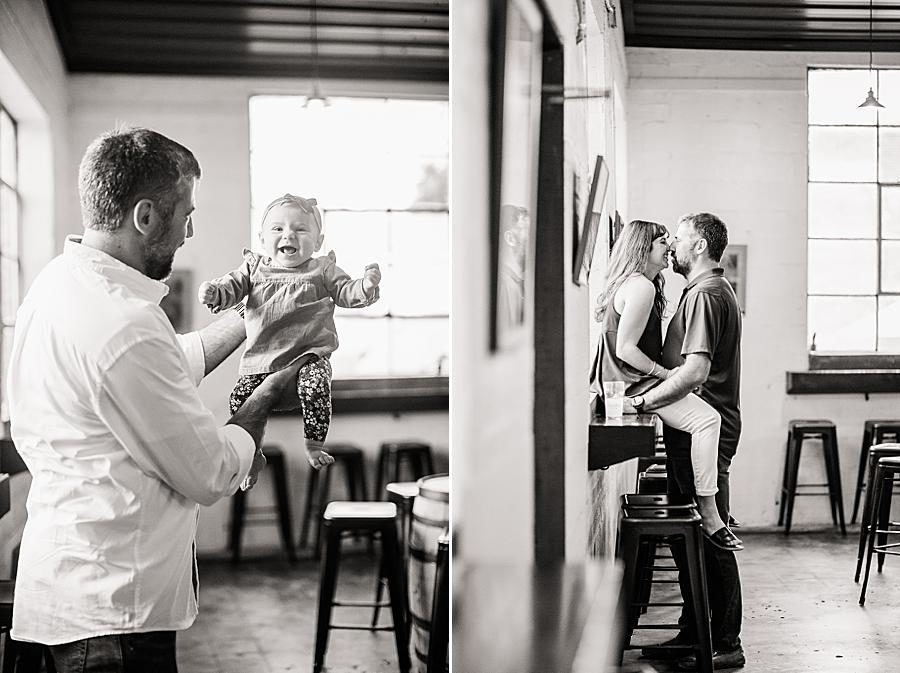 Holding a baby at this Printshop Brewery engagement by Knoxville Wedding Photographer, Amanda May Photos.