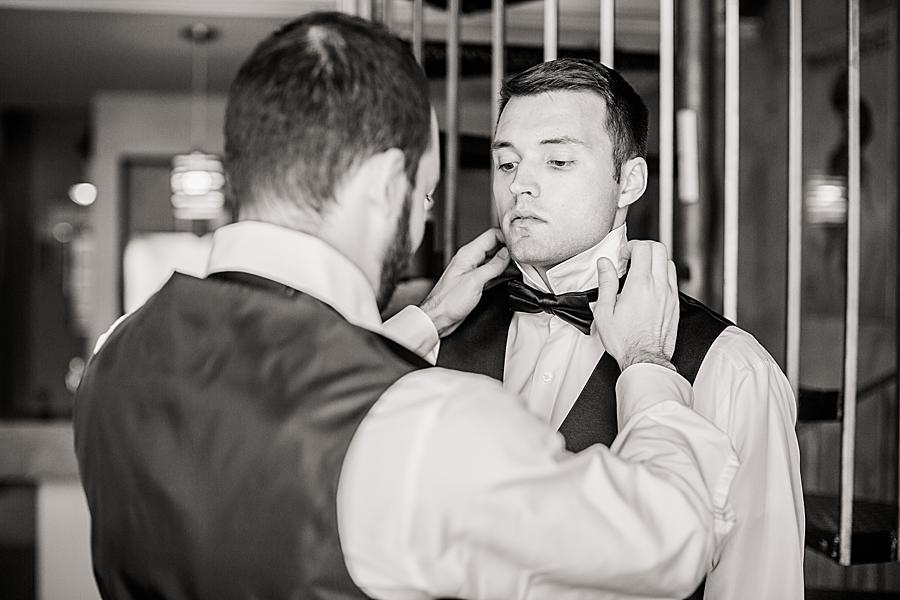 straightening the groom's tie