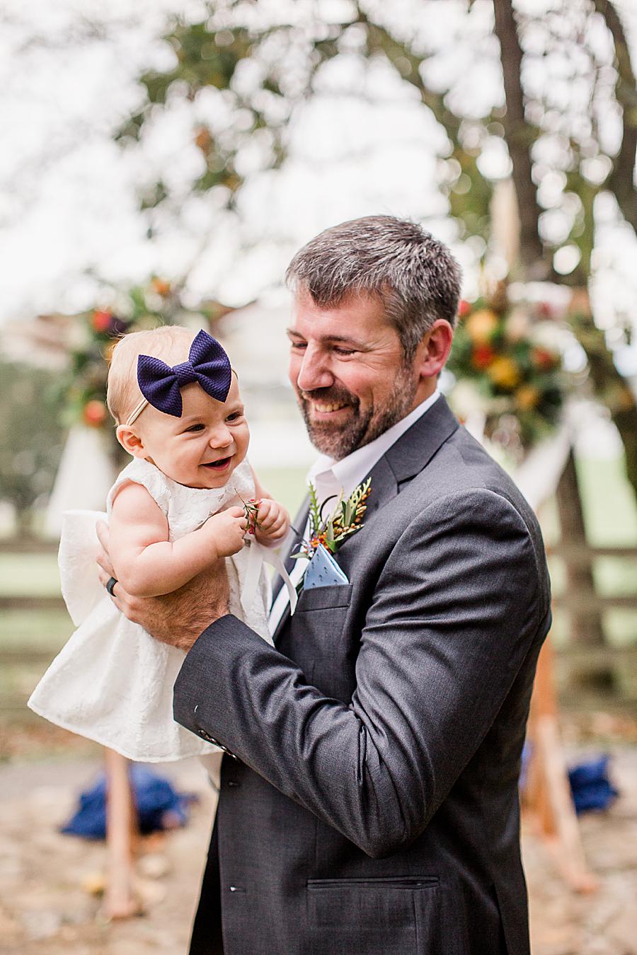 Holding daughter at this RiverView Family Farm wedding by Knoxville Wedding Photographer, Amanda May Photos.