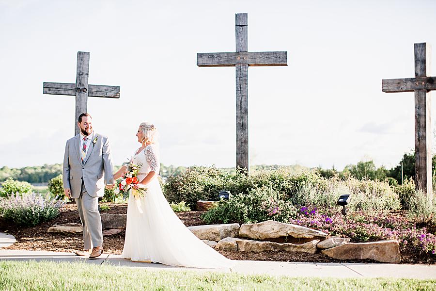 Couple in front of three crosses at their shoreline elopement