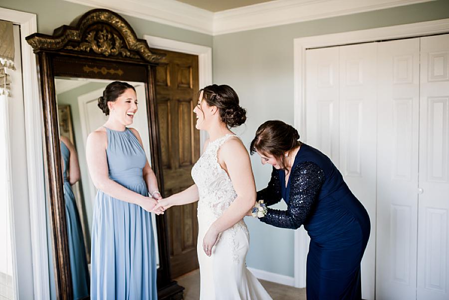 buttoning the wedding dress at this spring wedding at castleton