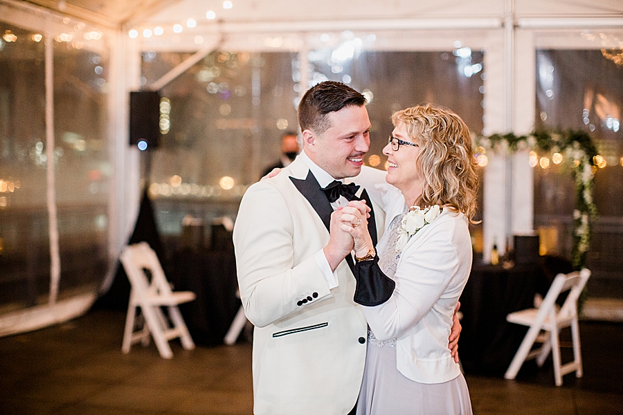 groom and mother dancing at the bridge building