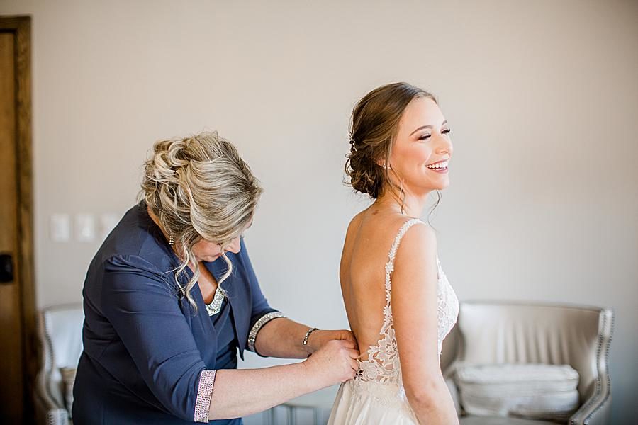 Buttoning wedding dress at this The Press Room Wedding by Knoxville Wedding Photographer, Amanda May Photos.