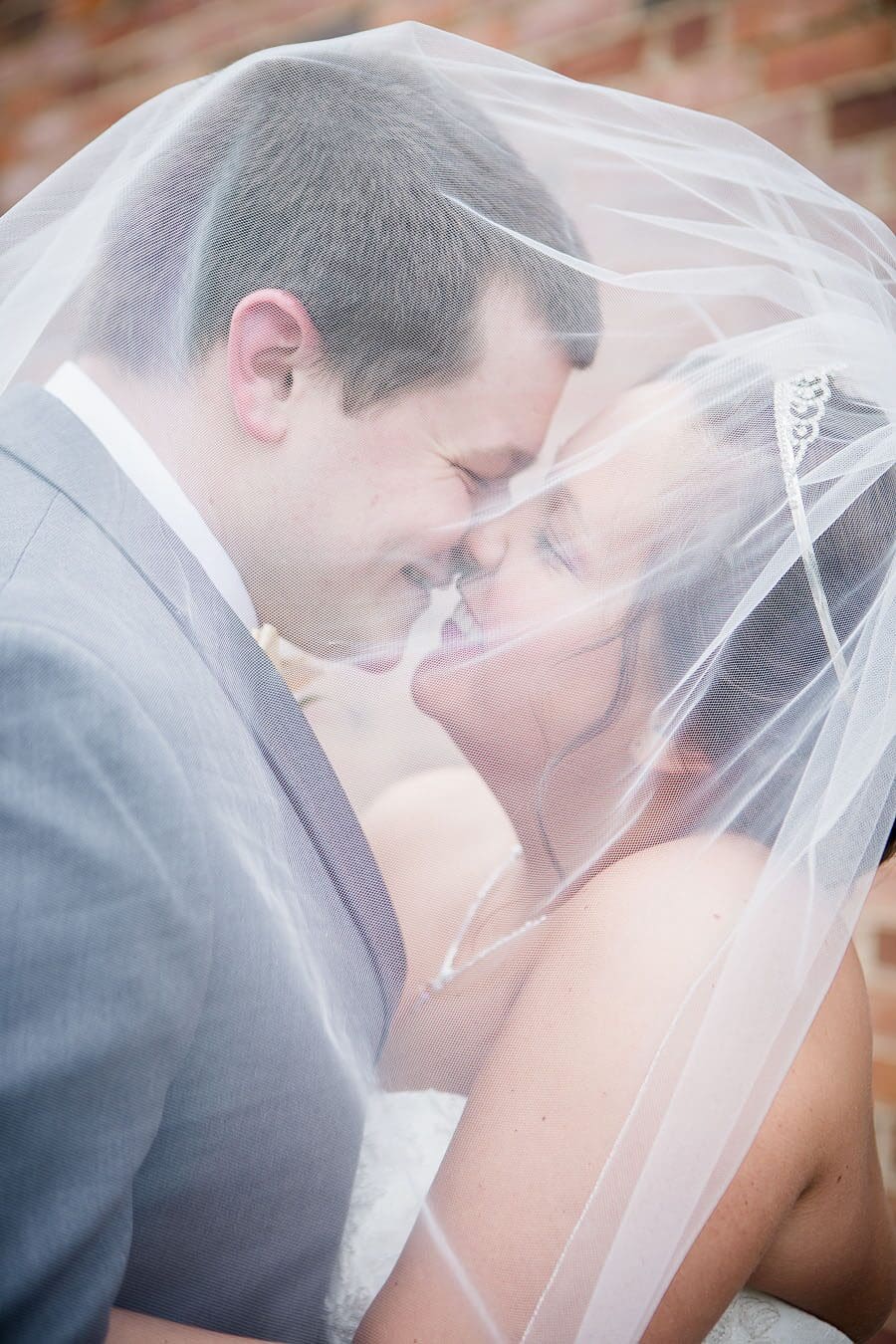 Kissing under vail at this favorite wedding photo by Knoxville Wedding Photographer, Amanda May Photos.