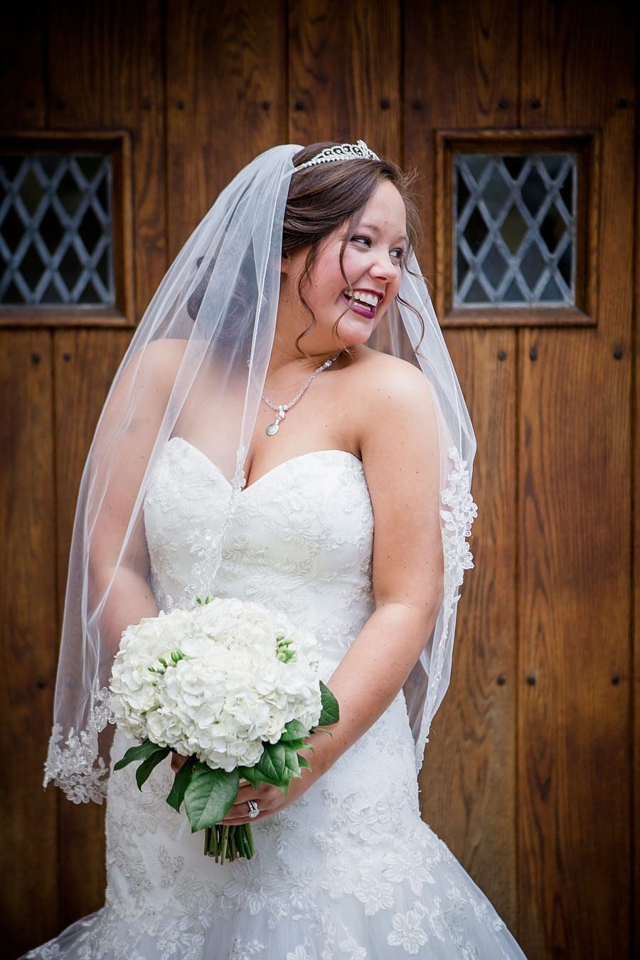 Bride in front of door looking to right at this favorite wedding photo by Knoxville Wedding Photographer, Amanda May Photos.