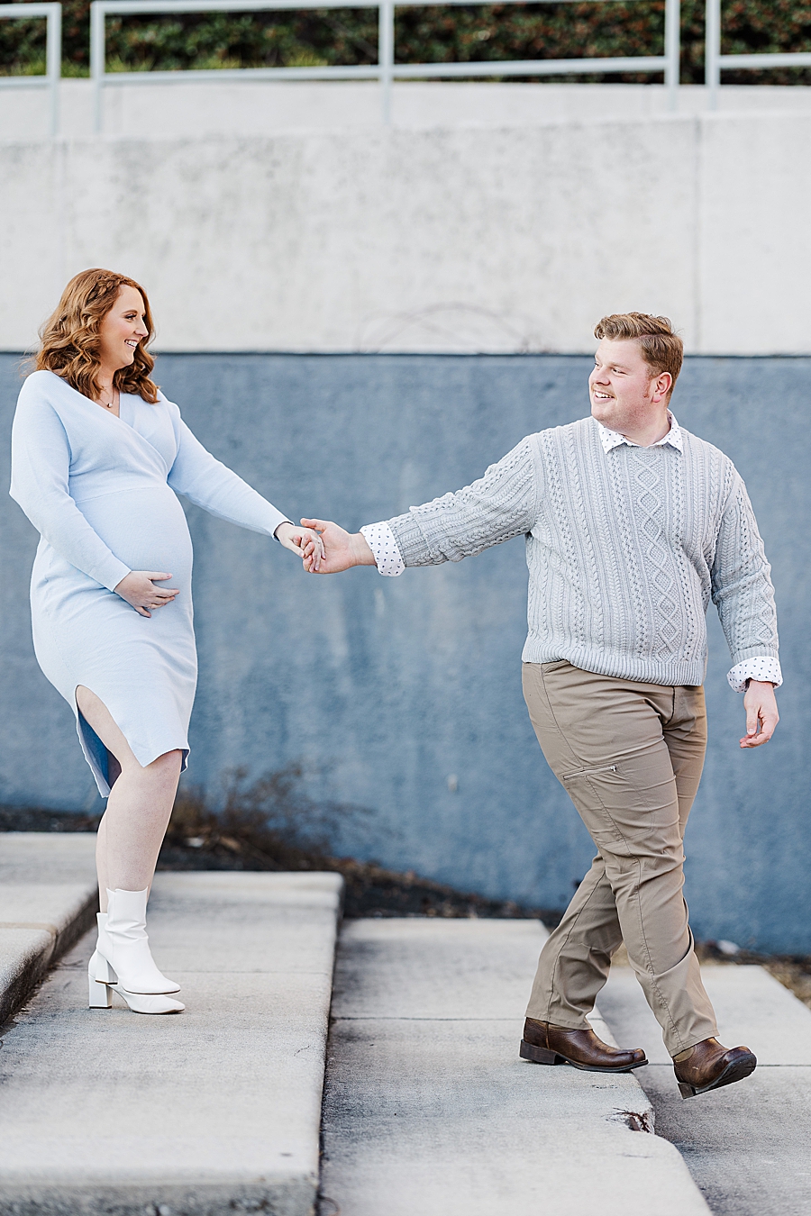 couple holding hands walking down stairs