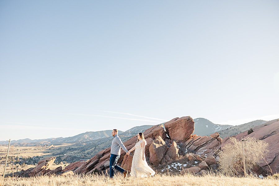 couple holding hands at red rocks engagement