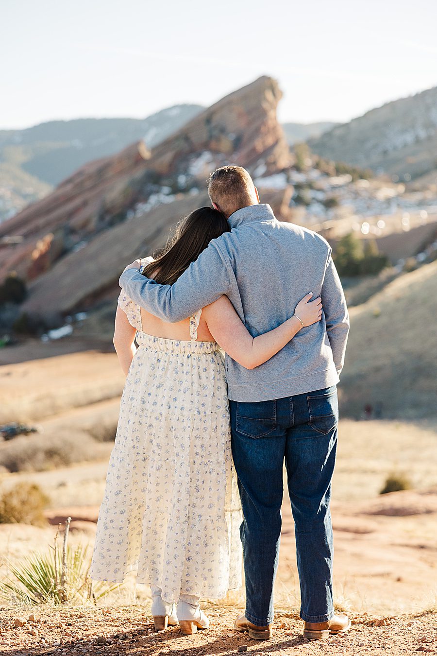 couple snuggling at red rocks engagement