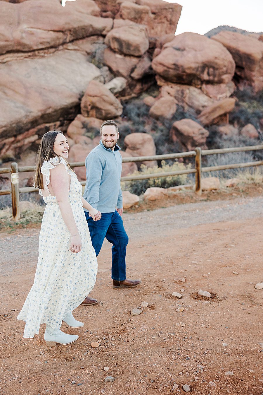 couple walking through red rocks 